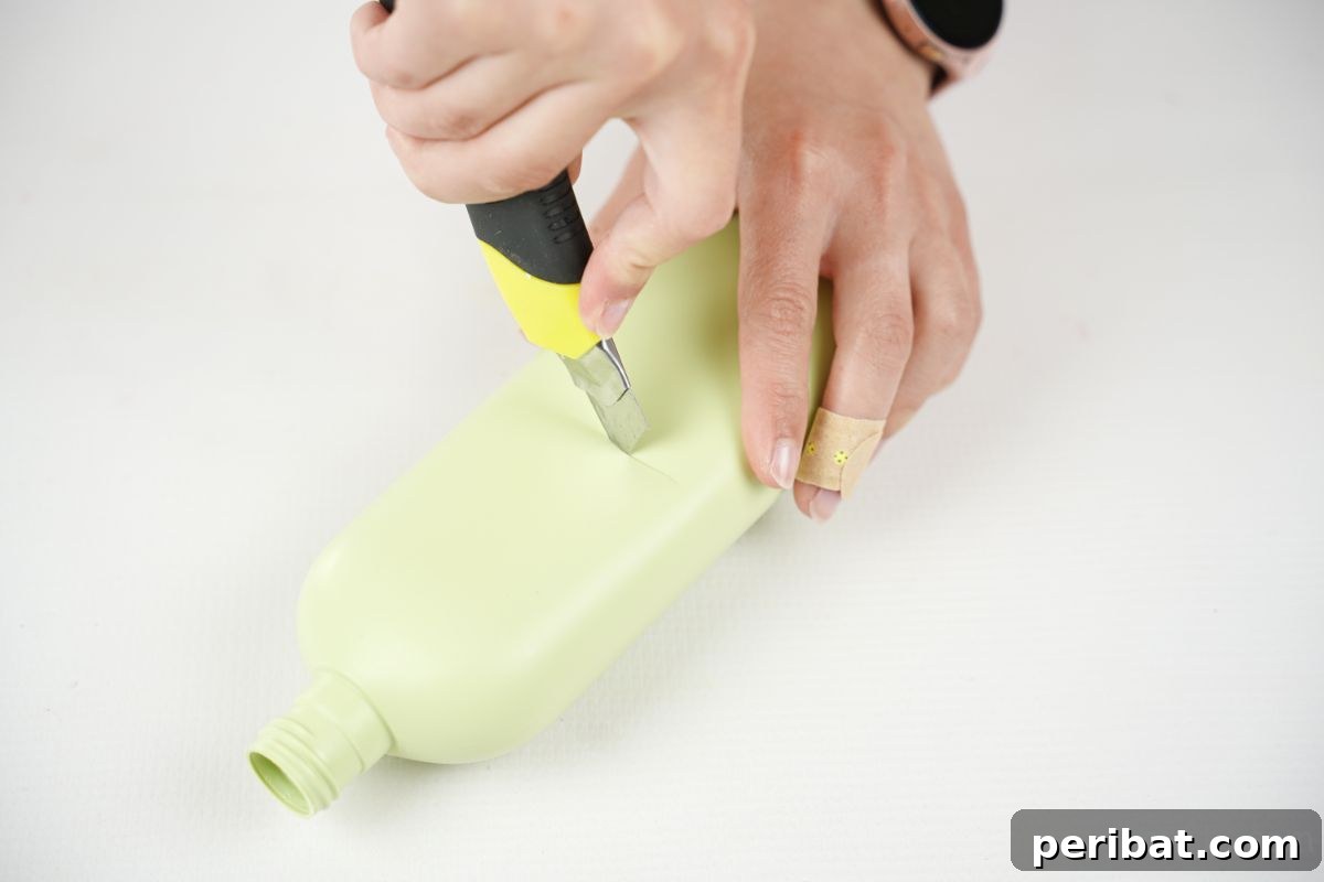 hand using craft knife to cut green bottle