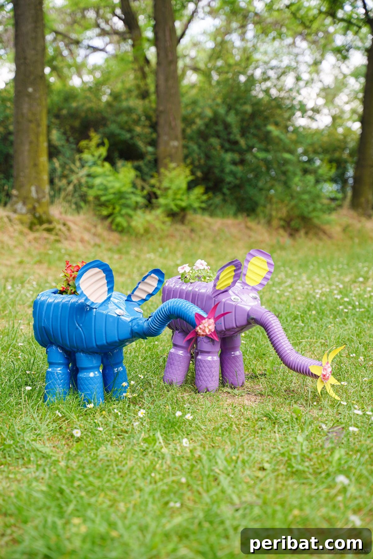Upcycled Bottles Blossom into Adorable Elephant Planters 2 blue elephant planter next to purple elephant planter on grass