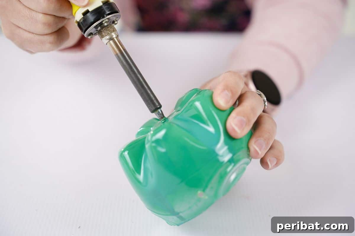 Beaded Bottle Breeze Song 13 soldering iron being held above bottle base