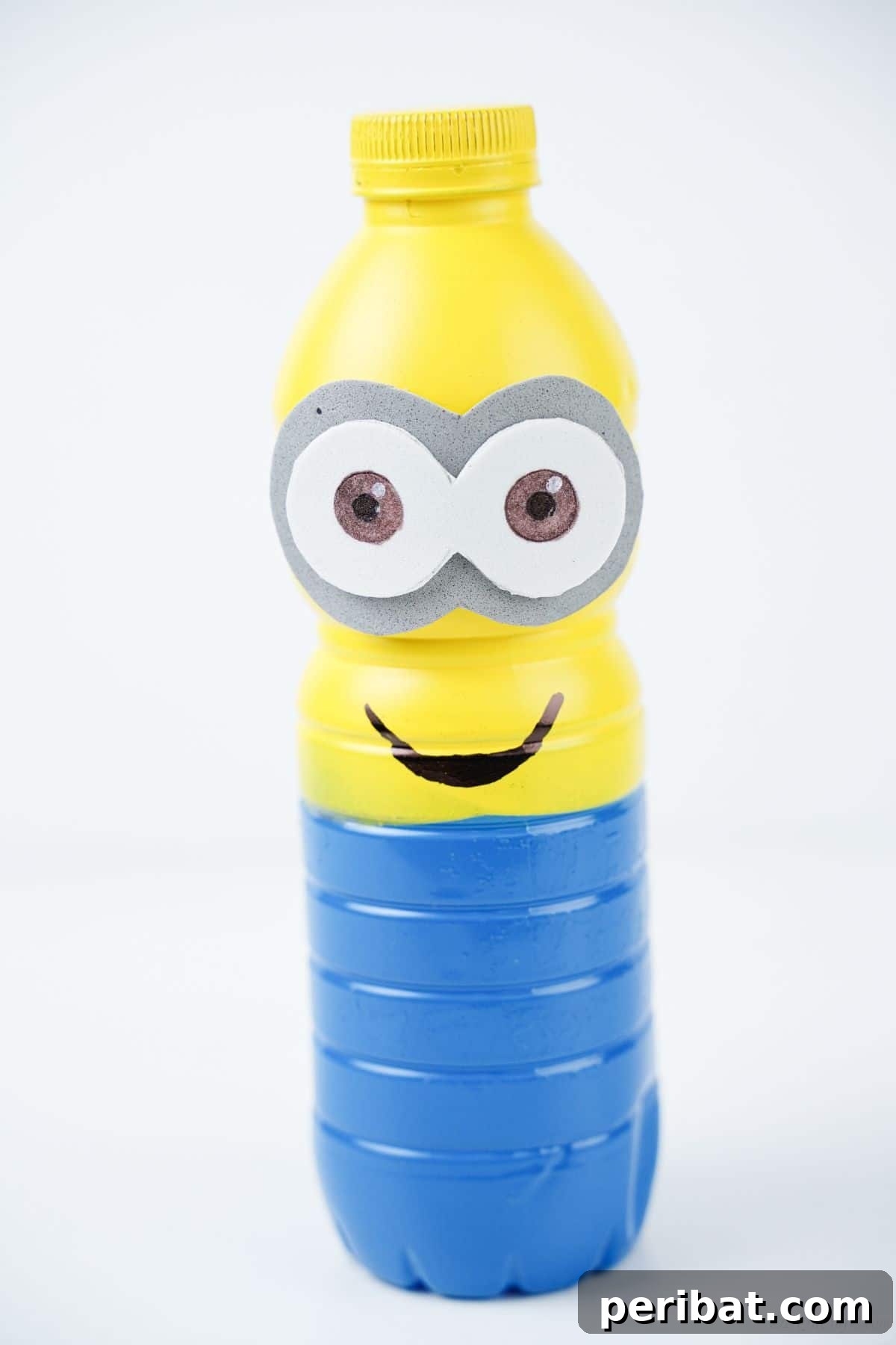 Upcycled Bottle Minion Creations 6 A vibrant plastic bottle Minion stands on a clean white table, ready to bring joy and creative inspiration.