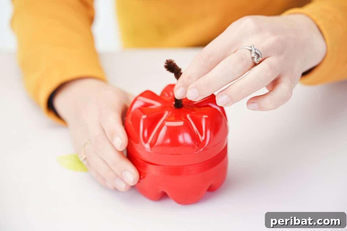 Charming Apple Plastic Bottle Teacher Gift 11 hand holding pipe cleaner above plastic bottle apple