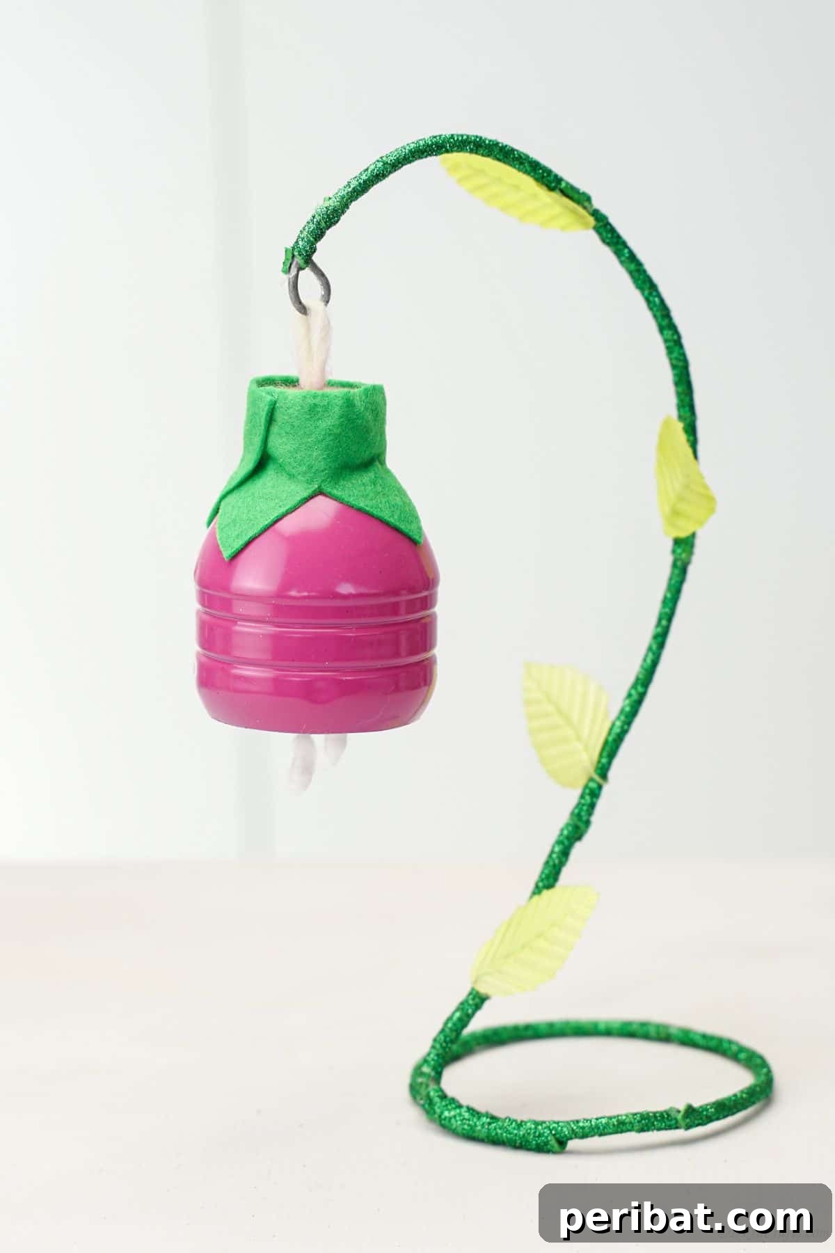Upcycled Plastic Bottle Blossoms 17 Close-up of a pink plastic bottle flower hanging on a green hook