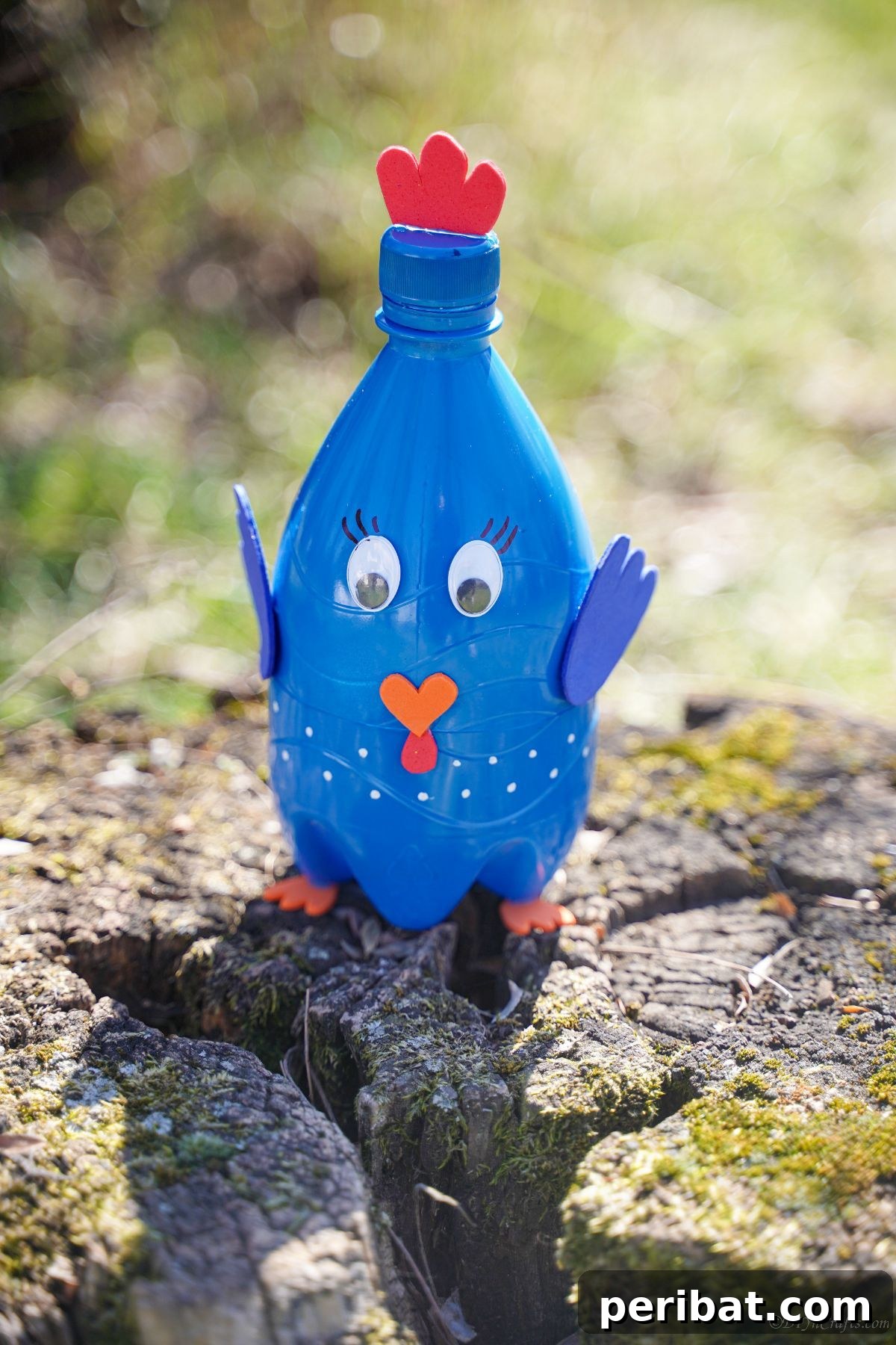 Close-up of the blue plastic bottle turkey craft on a tree stump, with natural light.