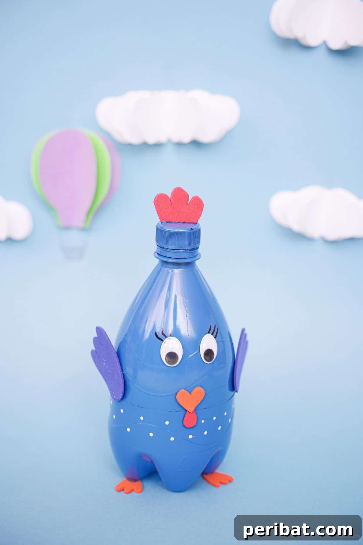 Plastic bottle turkey craft positioned against a vibrant blue sky background.