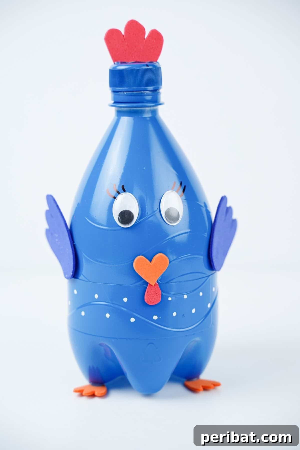 A beautifully crafted blue plastic bottle turkey sitting on a clean white table.