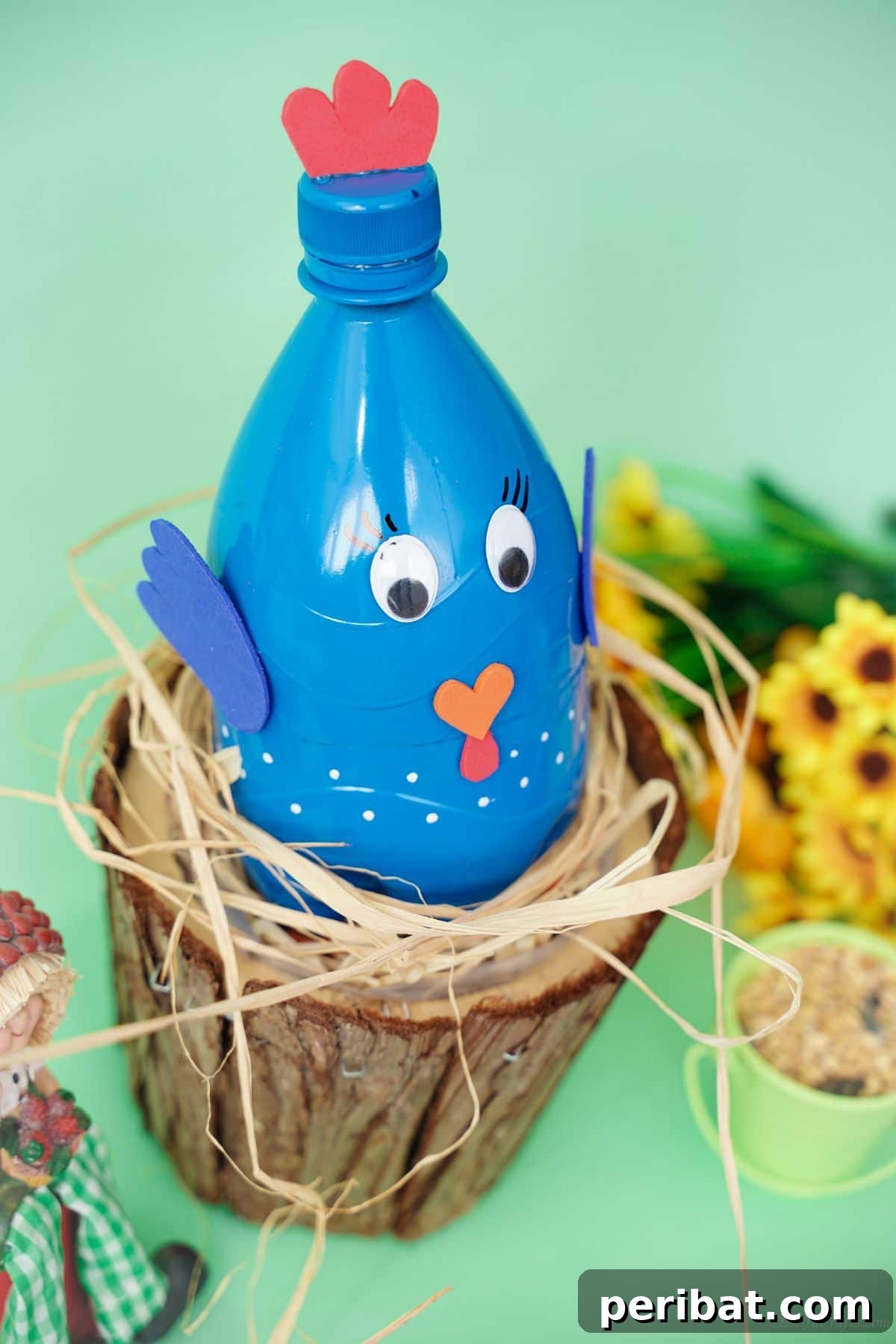 A blue fake bird craft sitting comfortably on a fake bird's nest.