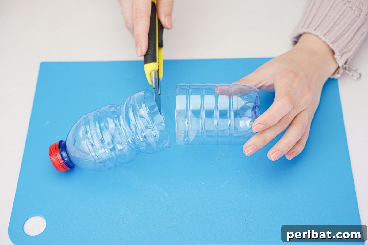 A yellow craft knife cutting an empty water bottle in half.
