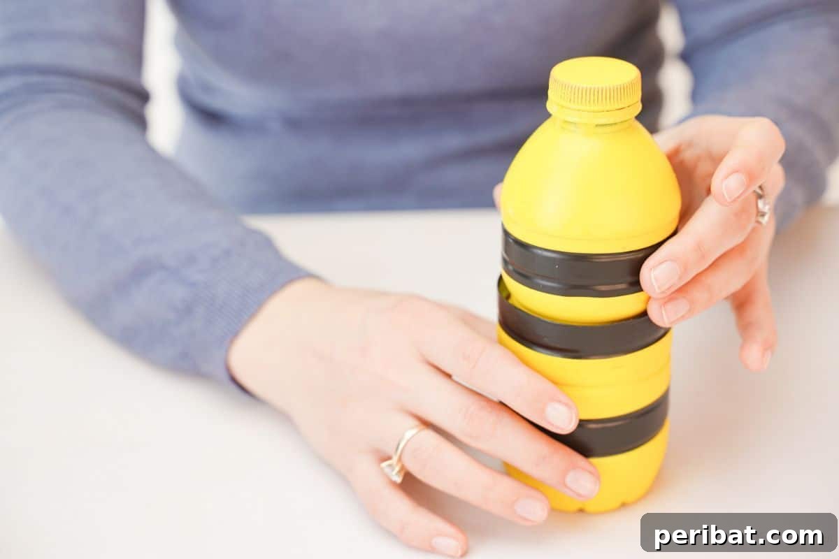 Yellow and black striped bottle held in woman's hands, demonstrating assembly.