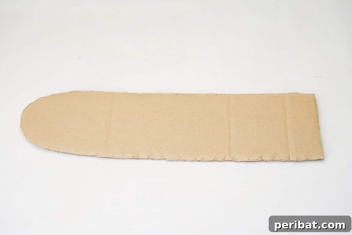 A strip of cardboard cut with one flat end and one curved end