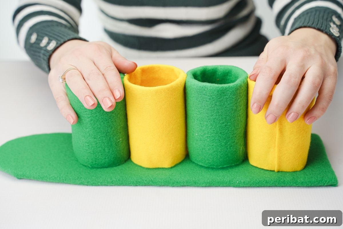 Green and yellow felt-wrapped plastic bottle bottoms glued to a green cardboard base