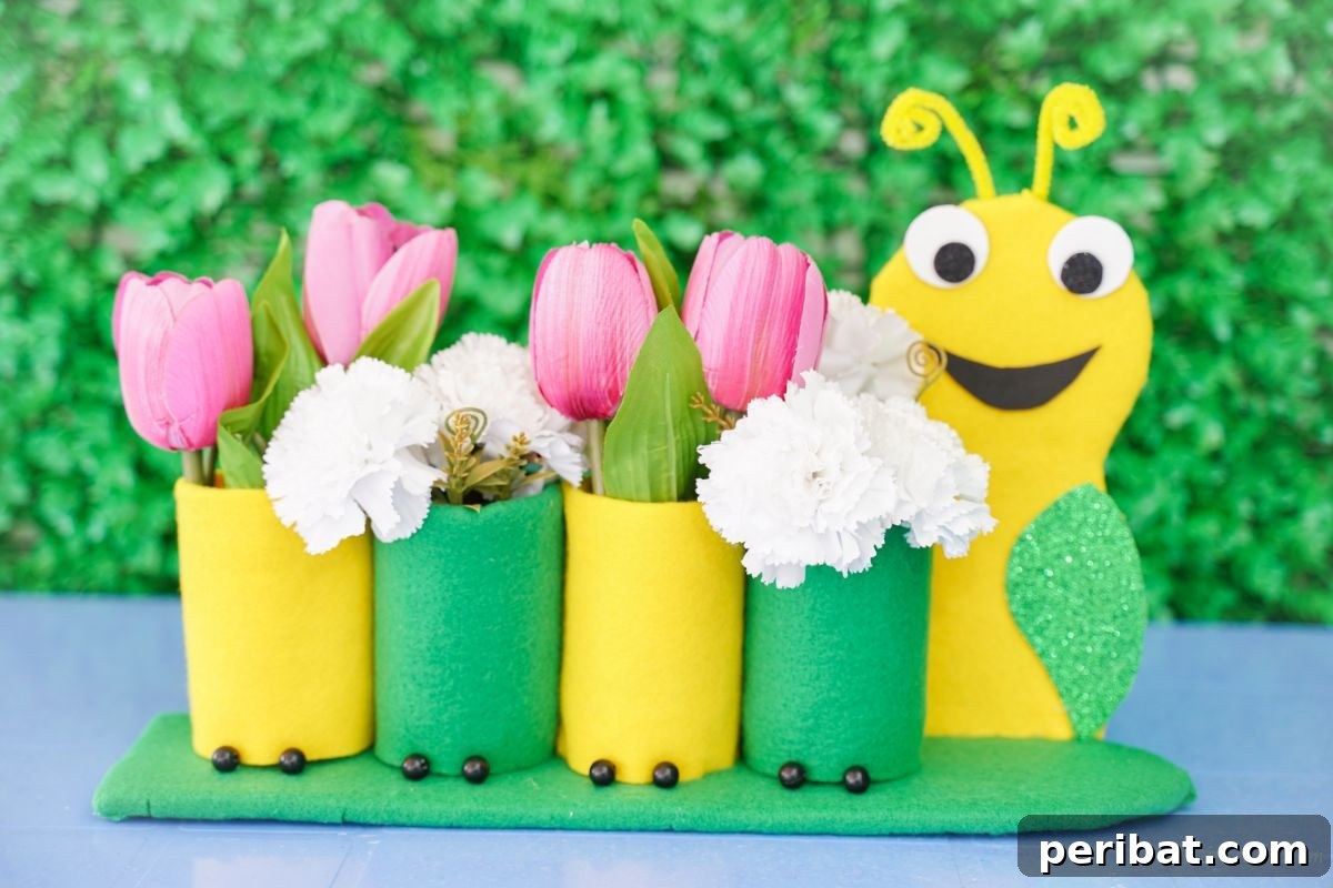 Completed caterpillar pencil holder with flowers in front of a green shrub background