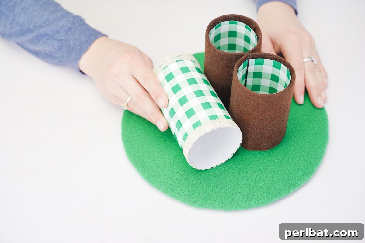 Hands assembling the dog pencil holder base, gluing the covered bottles onto the green felt circle.