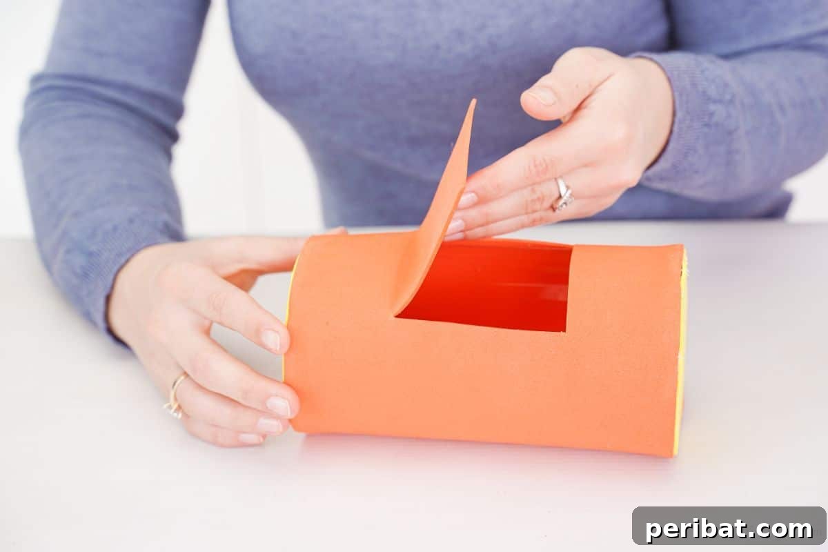 Orange foam paper wrapped around the plastic bottle car body, with an opening on top, resembling a car's roof.