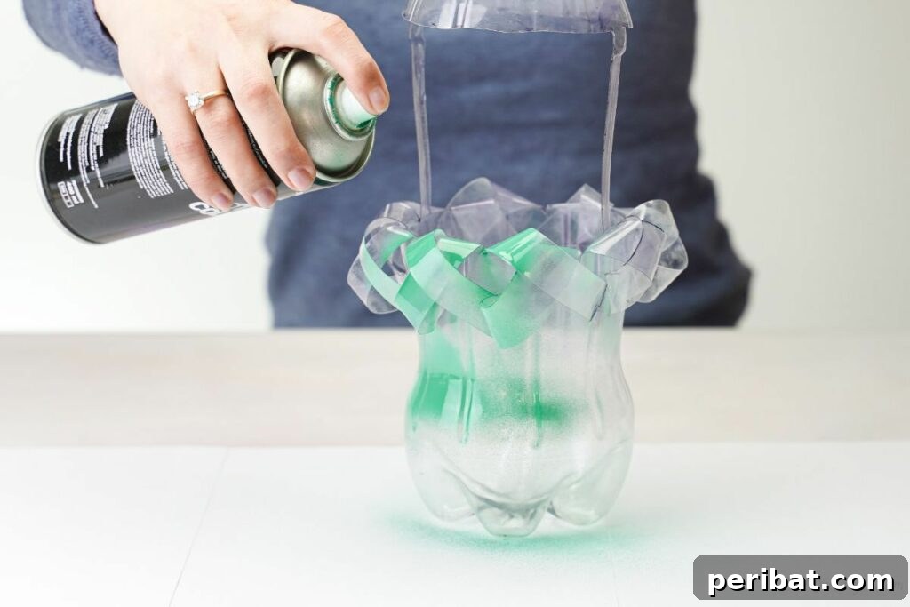 Soda Bottle Hanging Gardens 2 hand spraying green paint onto plastic bottle planter