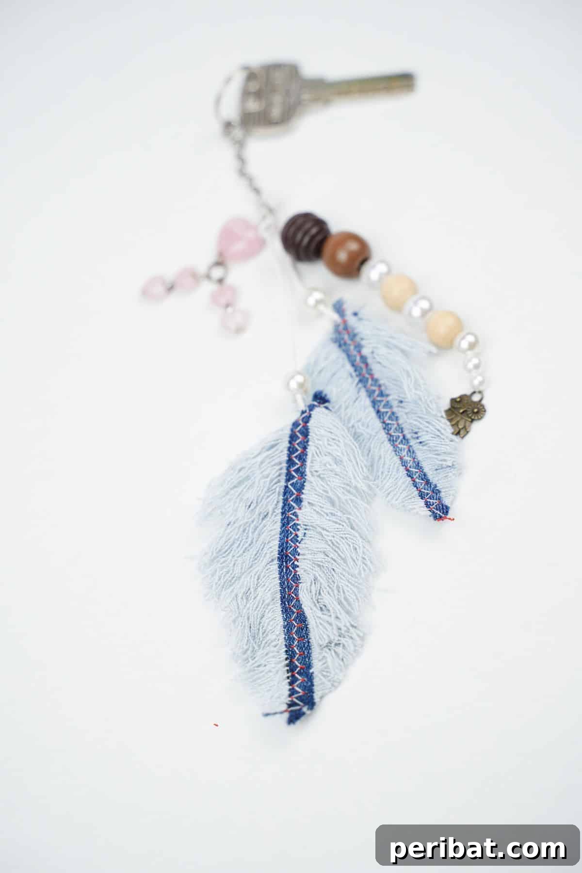 Handmade Denim Feather Keychain 8 denim feather keychain laying on white table