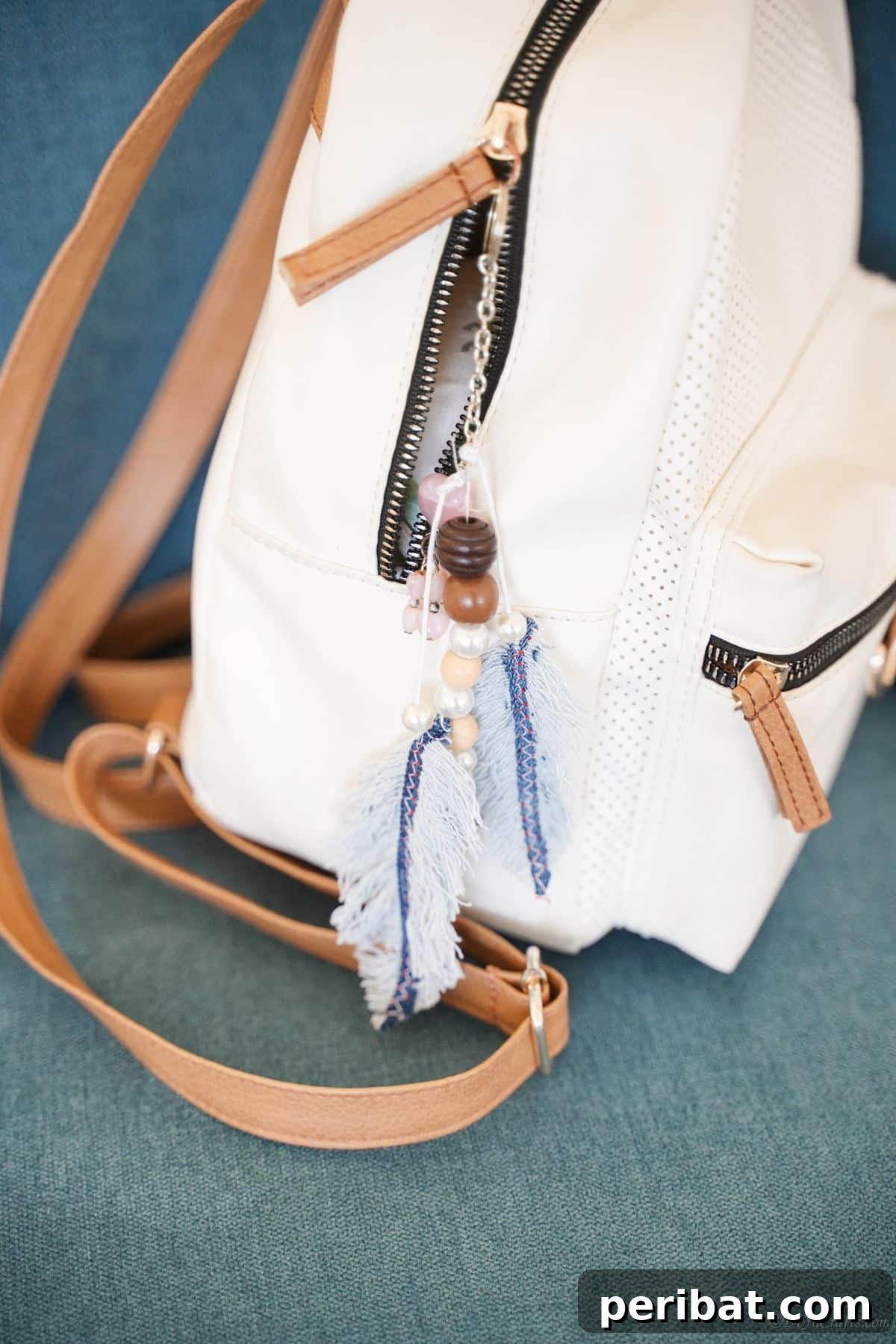 Handmade Denim Feather Keychain 9 denim feather keychain hooked on side of white backpack purse