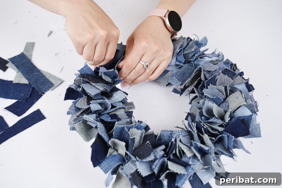 Denim Delight: Simple Wreath from Upcycled Jeans 4 hands pushing the last bit of denim in to cover foam wreath