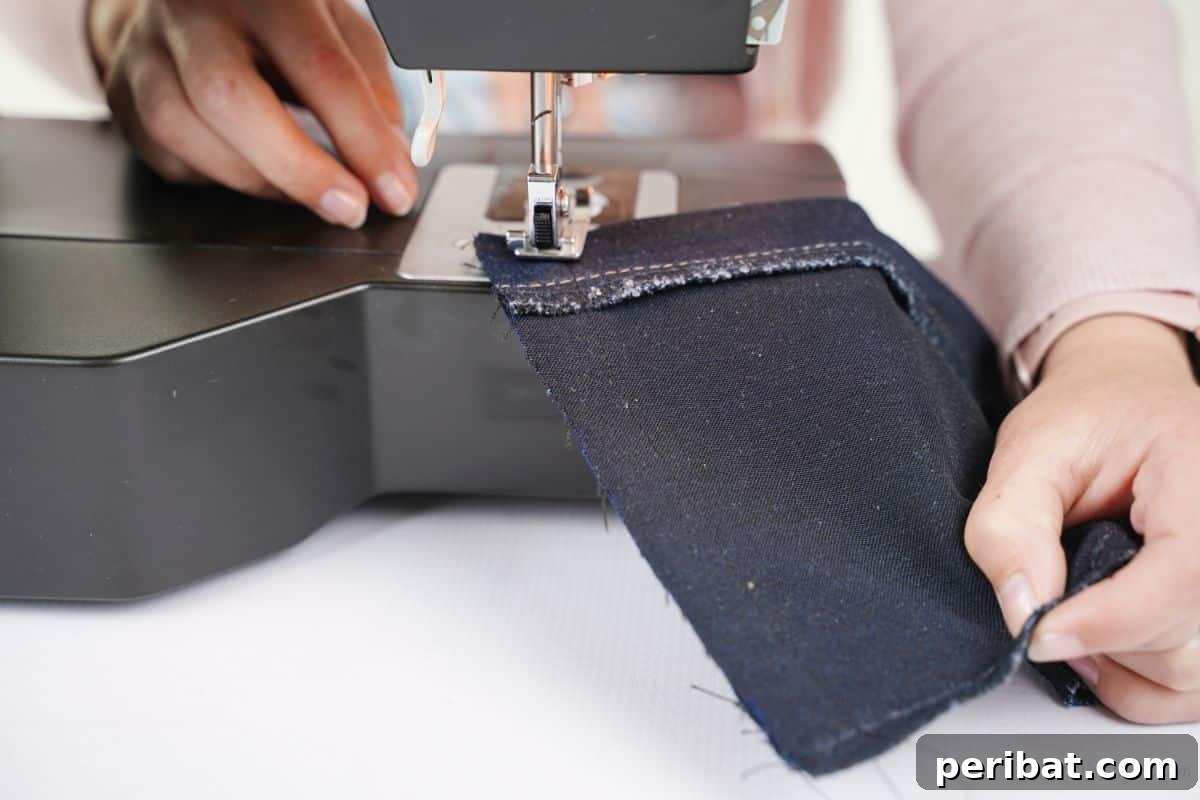 Rustic Denim Wine Cozy 3 Denim being sewn on a sewing machine, forming the base of the wine bottle cover.