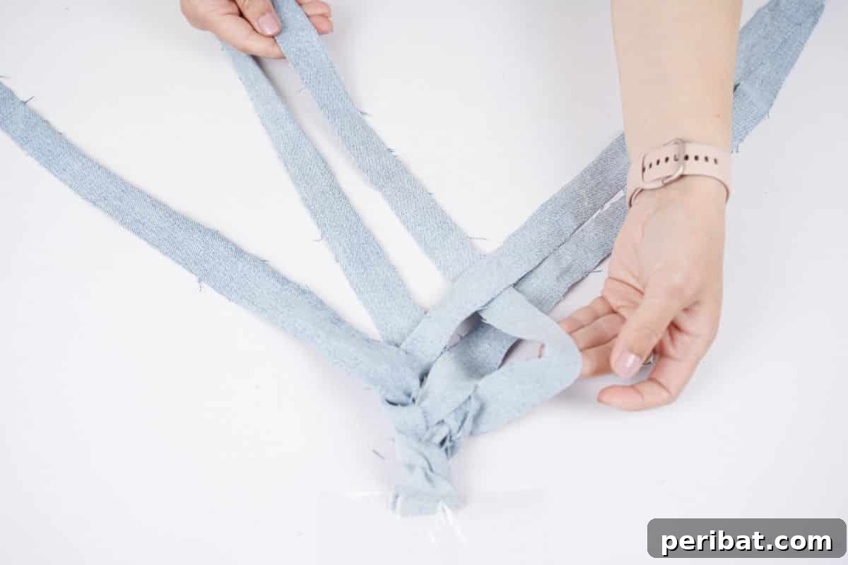 Denim Reimagined: Braided Headband DIY 13 Close-up of hands braiding denim ribbons