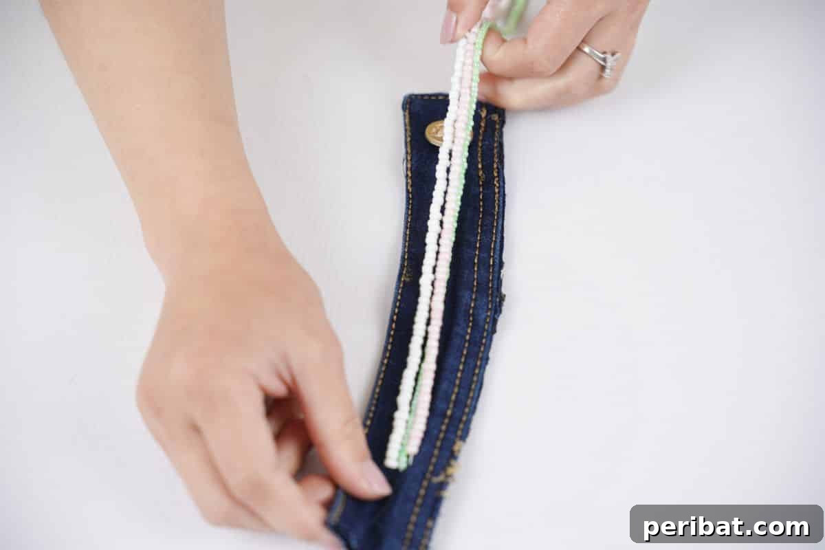 Denim Reborn Wristwear 5 Various craft embellishments, including beads, fabric, and thread, laid out for decorating a denim cuff
