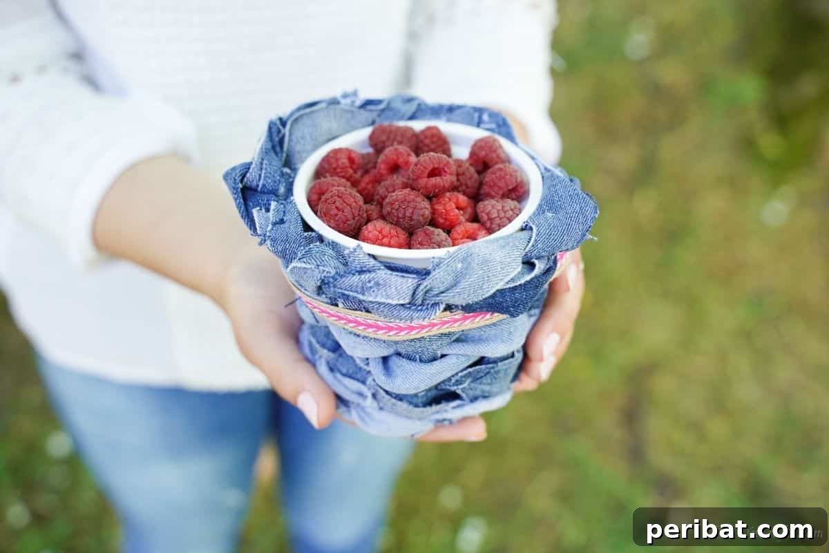 Rustic Denim Planter Basket 19 A woman holding the finished denim basket planter cover with raspberries
