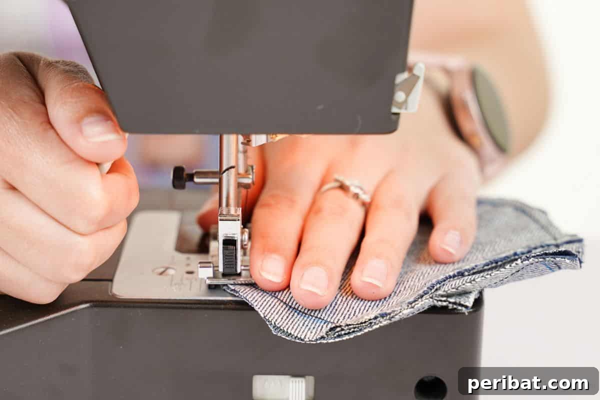 denim heart being sewn by black sewing machine