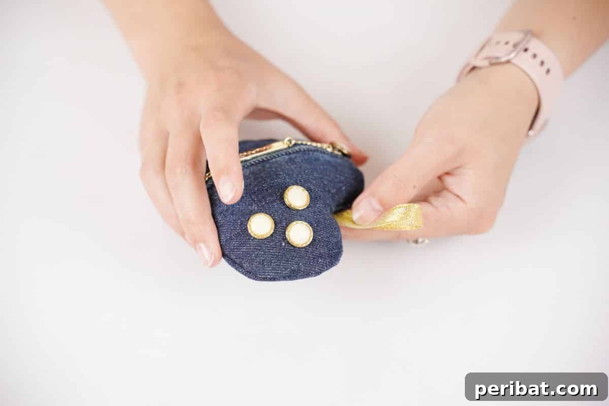 gold ribbon loop being glued onto top of heart sachet