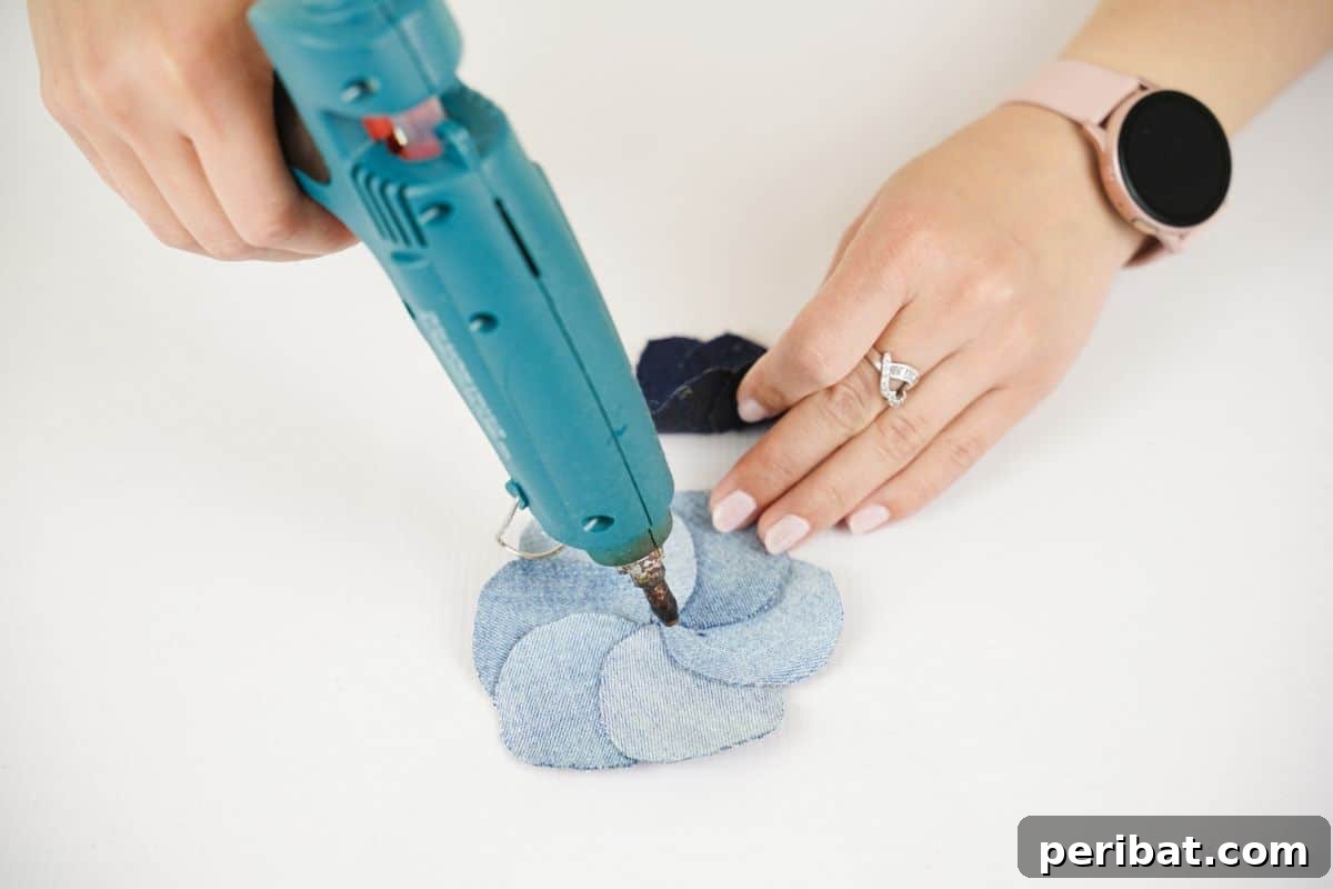 Blossoming Denim Transform Old Jeans into Flower Appliques 7 glue gun being used on top of light denim flower shape