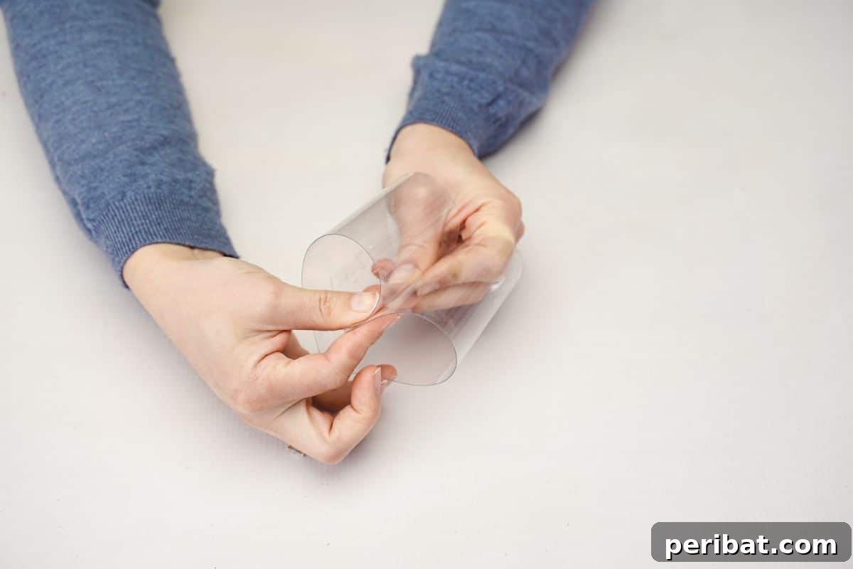 From Bottle to Heart: Upcycled Gift Box Craft 4 Hand shaping a cut plastic bottle section into a distinct heart form.