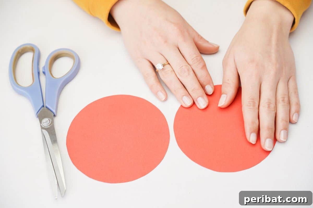 Two red paper circles on a white table, ready to be folded.