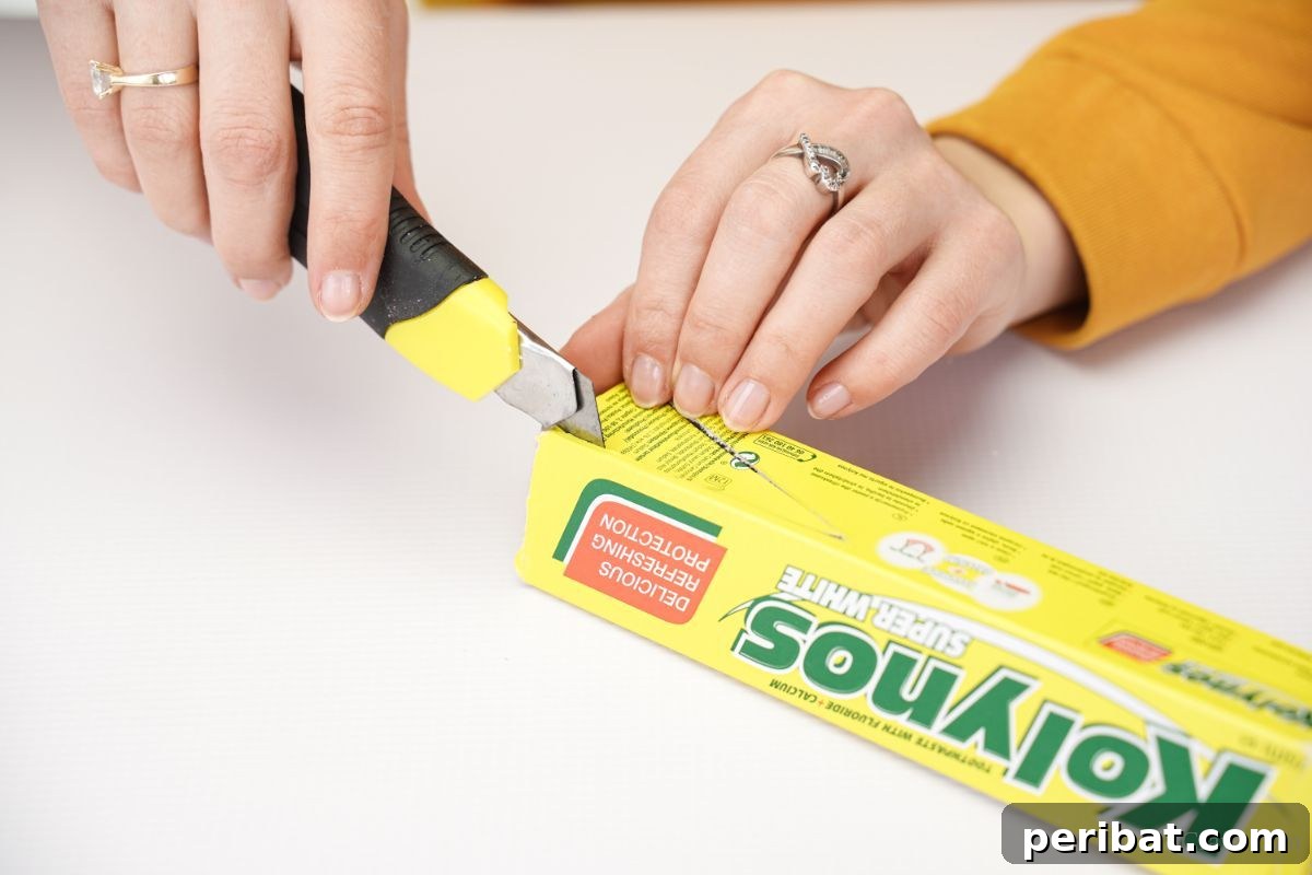 Transform Boxes into Race Cars: Kids Craft Fun 7 Craft knife carefully cutting into an empty toothpaste box along traced lines