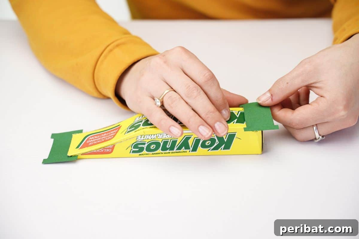 Transform Boxes into Race Cars: Kids Craft Fun 6 Green tail fin piece being glued onto the back of a yellow box race car
