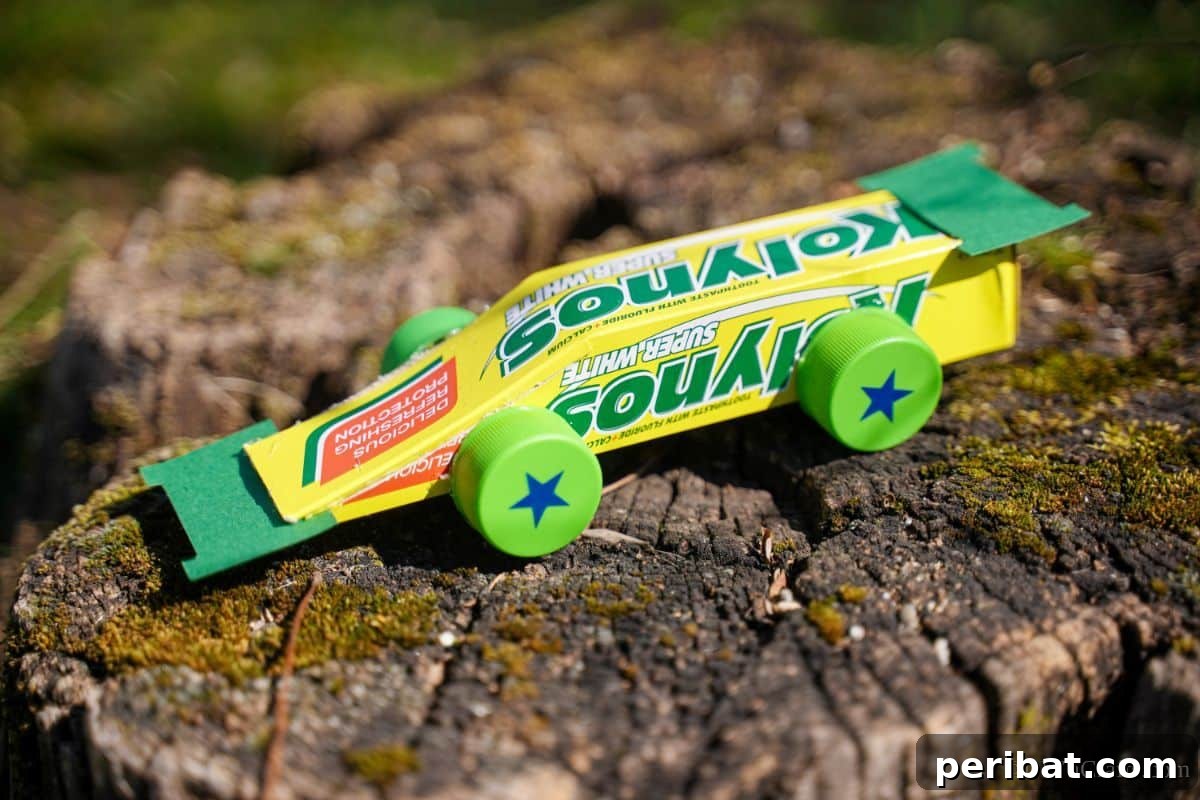 Transform Boxes into Race Cars: Kids Craft Fun 9 Green and yellow upcycled box race car craft sitting outside on a wood stump, showcasing the finished product