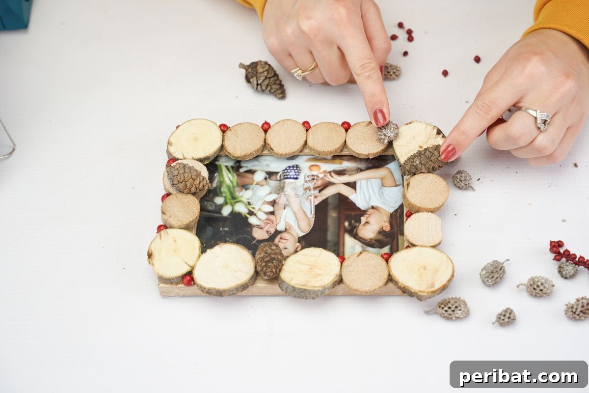 Tree Ring Photo Frame 4 hand adding mini pinecones to side of wood slice picture frame