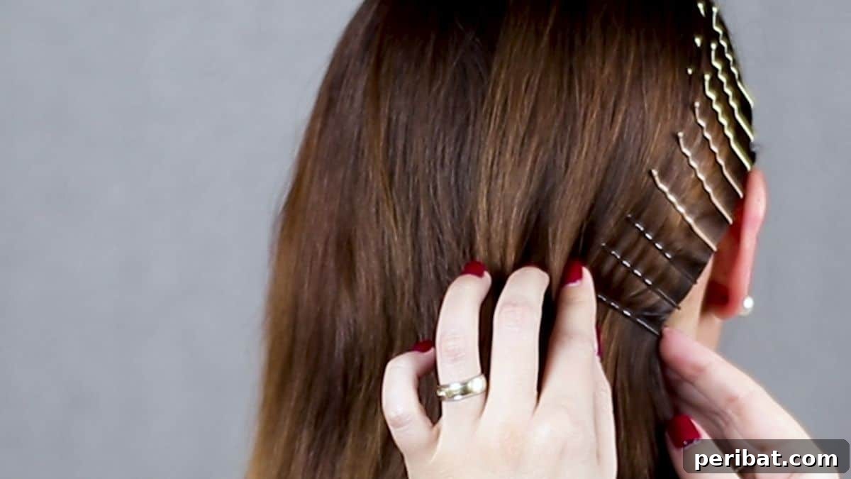 Braided Bobby Pin Glam 10 hand with red nails adding bobby pin to brown hair
