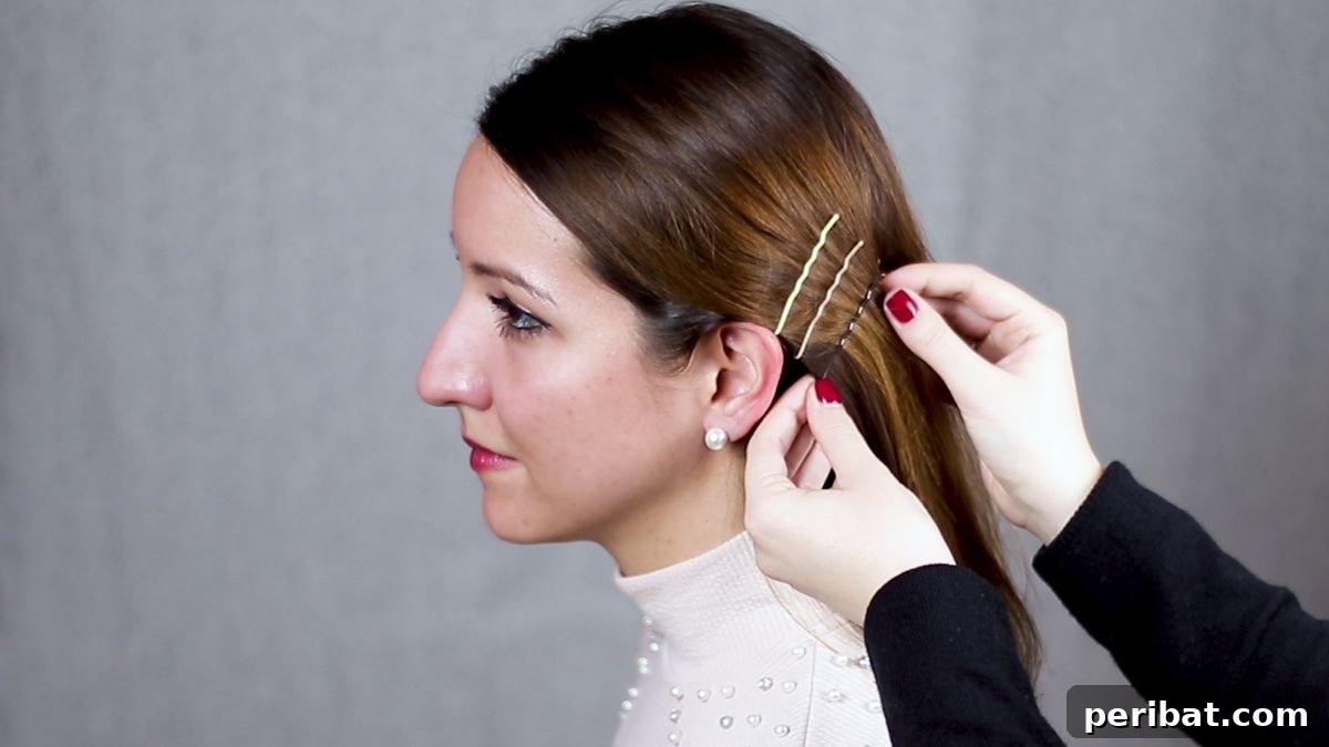gold bobby pin sliding into hair behind ear