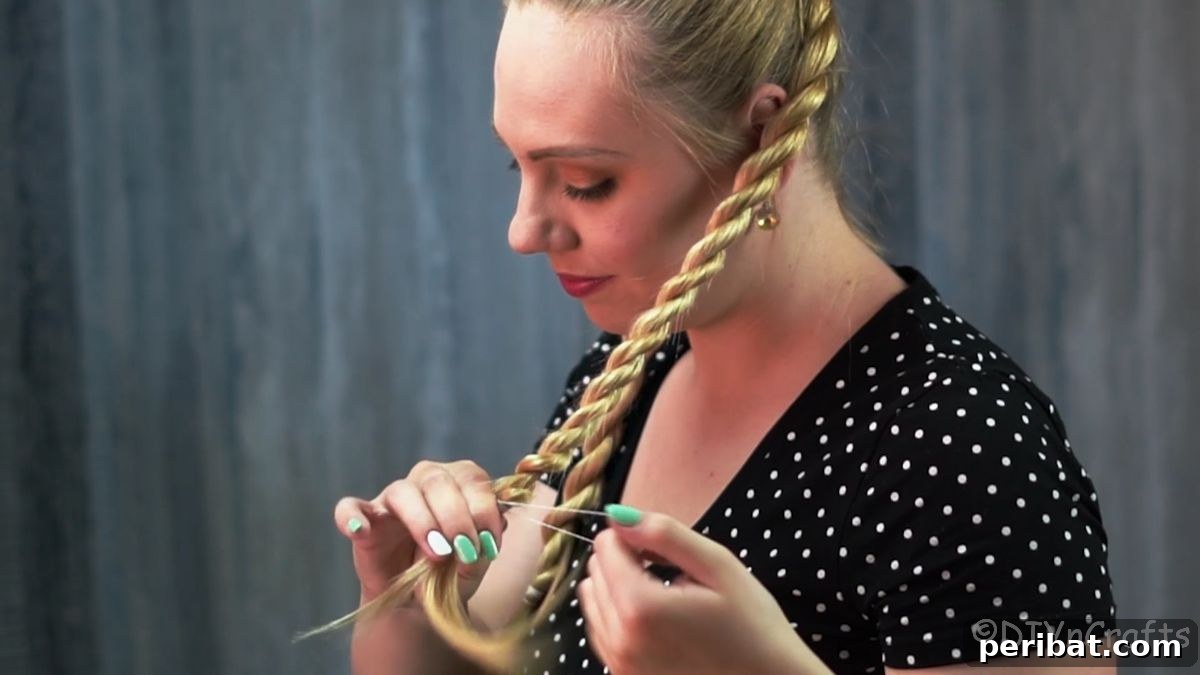 Stunning Braided Donut Bun Updo 11 Hand securing the end of a twisted braid.