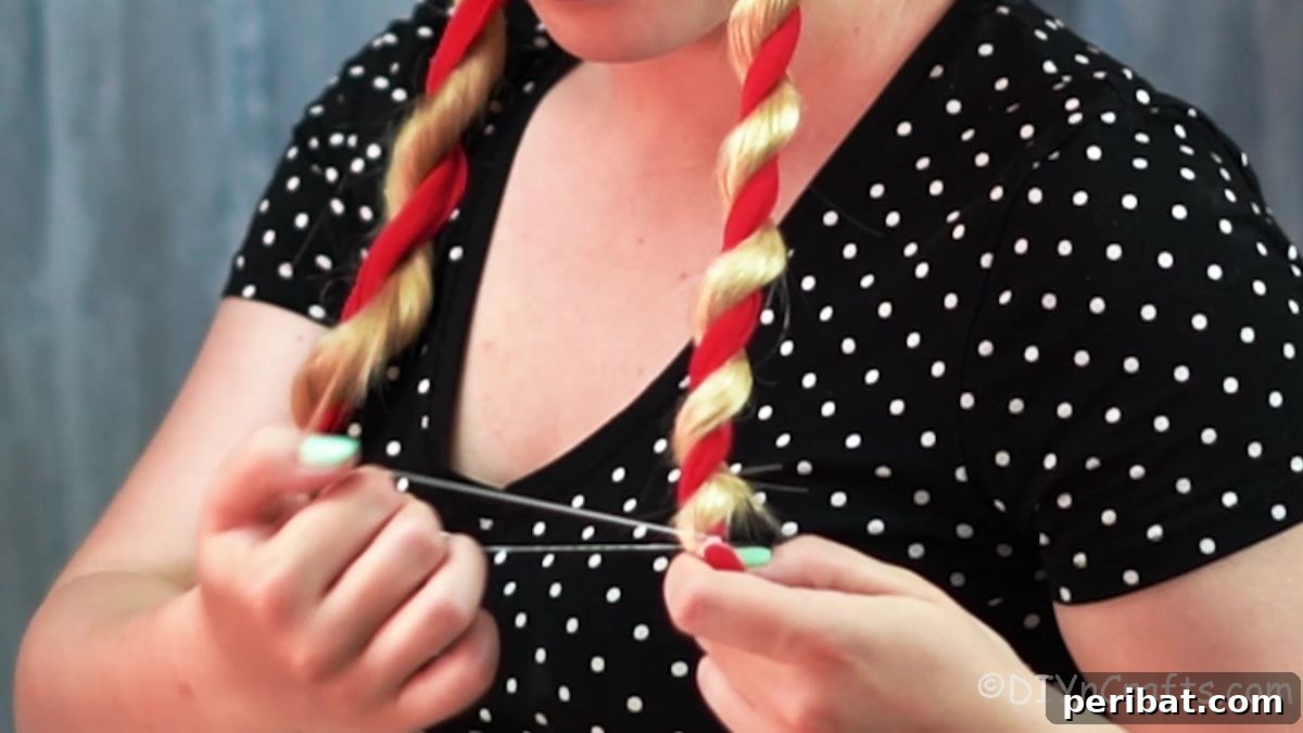 Twisted High Bun with Ribbon Accent 7 A small hair tie being added to secure the end of a hair twist integrated with a red ribbon, completing one twisted section.