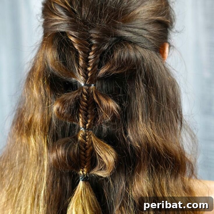 Fancy Palm Tree Bubble Braids Half-Updo 2 A woman showcasing the elegant Palm Tree Bubble Braids half-up hairstyle on long, wavy brown hair.