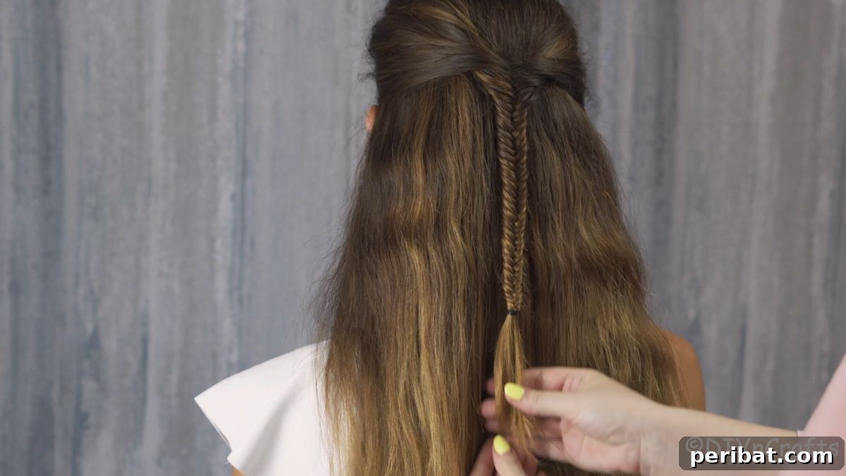 Fancy Palm Tree Bubble Braids Half-Updo 7 Hand adding hair tie to the completed fishtail braid section.