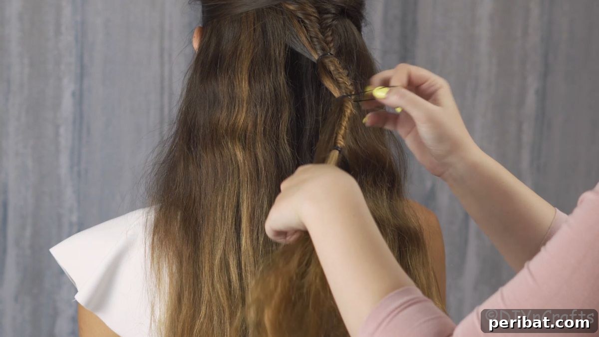 Fancy Palm Tree Bubble Braids Half-Updo 9 Close-up of tying extra hair onto the main braid to form a bubble.