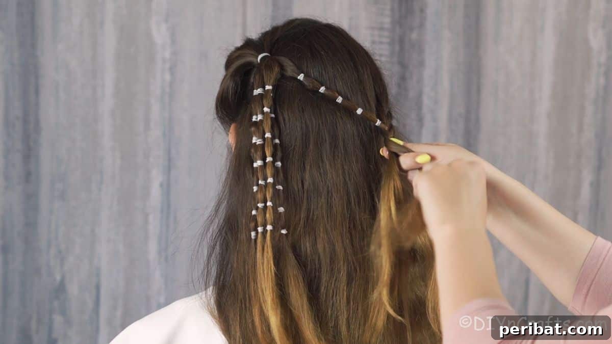 Playful Waterfall Bubble Half-Updo 11 Hand adding bubble braid into waterfall braid