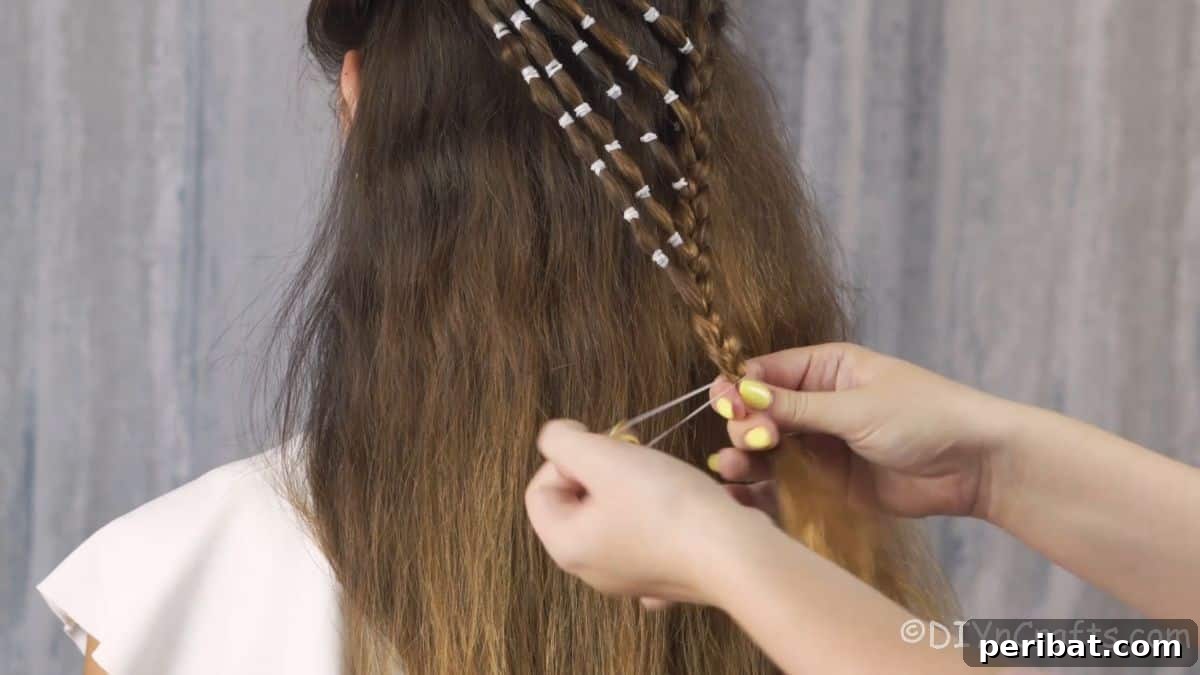 Playful Waterfall Bubble Half-Updo 12 Hand adding elastic tie to bubble braid