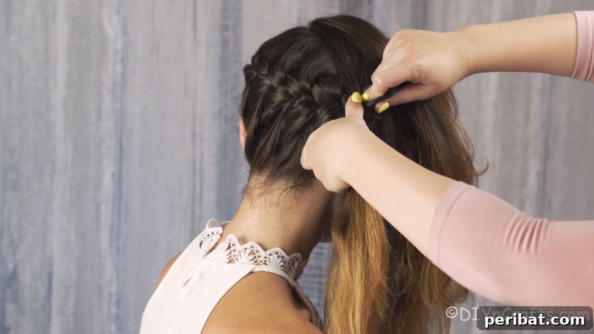 Whimsical French Crown Braid 4 A close-up of hands braiding hair, showing the technique.