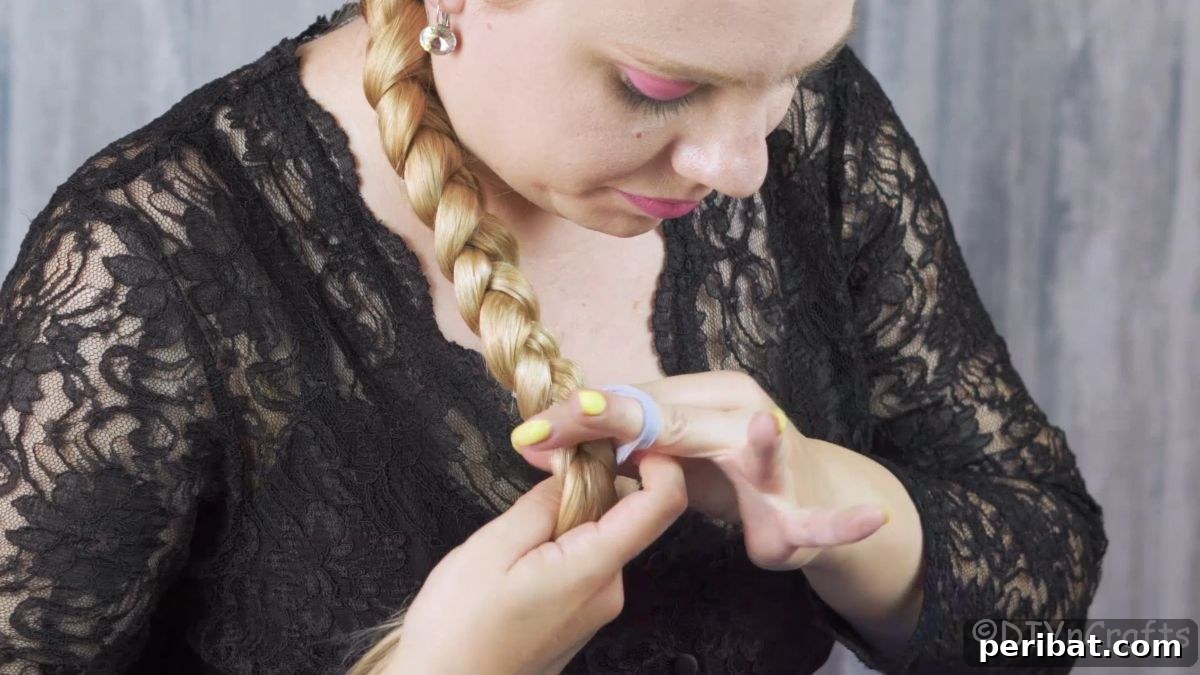 Artfully Twisted Low Braided Ponytail 13 Securing the end of the low ponytail braid with a hair tie