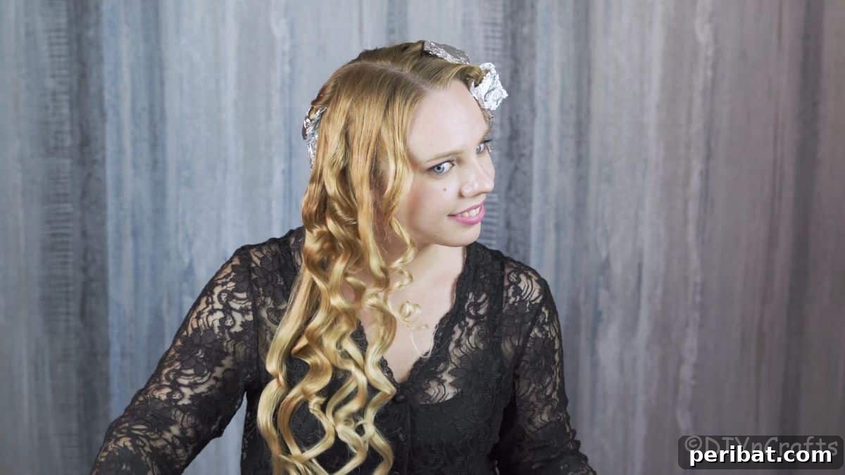Aluminum Foil Curls Made Easy 7 A blonde woman carefully unwrapping a section of her hair from the aluminum foil, revealing a perfectly formed curl. This marks the exciting moment of seeing the results.