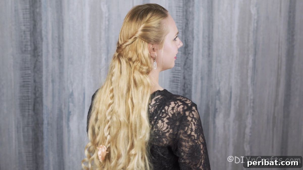 A complete half up twisted braid hairstyle, beautifully styled with wavy hair, and adorned with a decorative element.