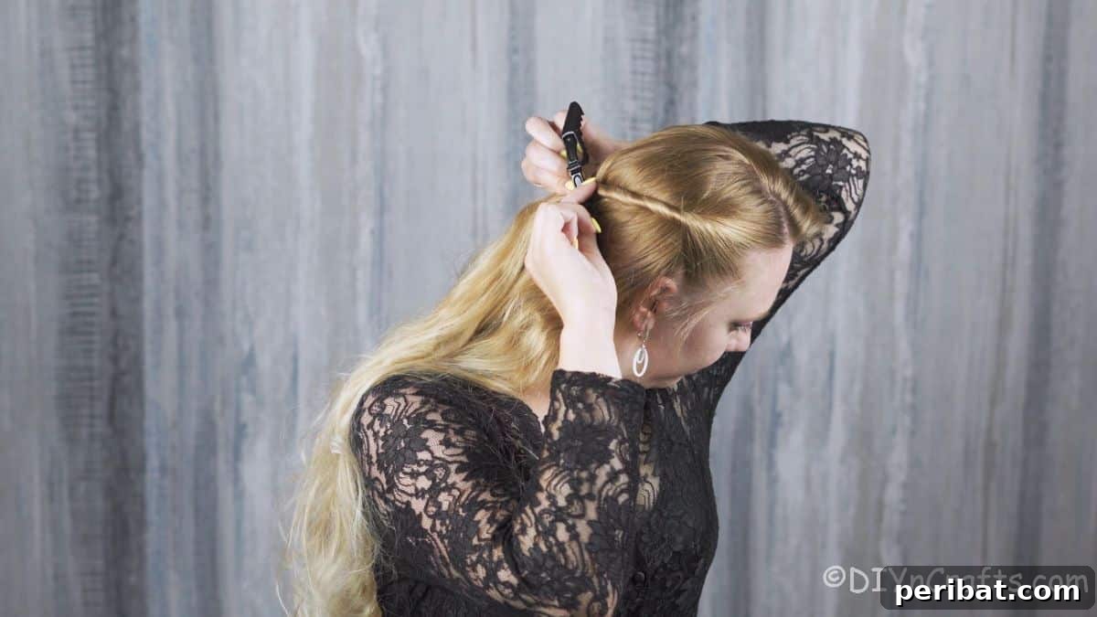 Close-up of blonde hair being carefully twisted back towards the crown, demonstrating the initial step.