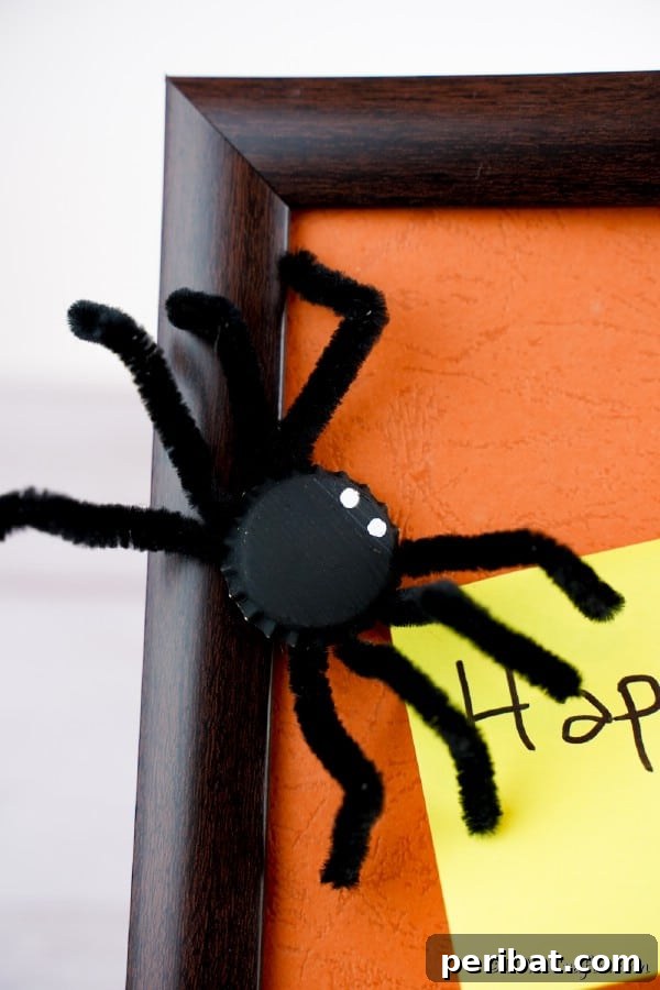 A charming Halloween bottle cap spider magnet cleverly attached to the side of a picture frame, adding a touch of festive flair.
