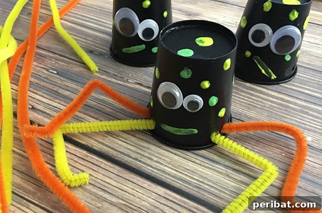 A playful spider craft made from paper cups, displayed on a rustic wood table, perfect for kids' Halloween activities.